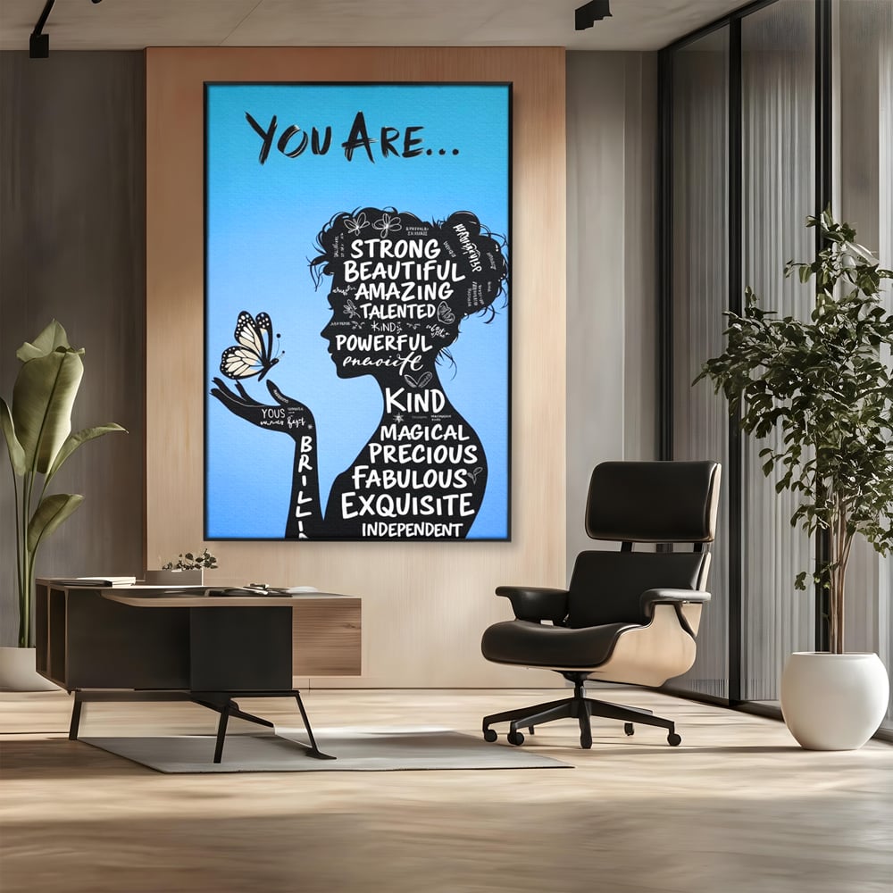 Tablou canvas cu tablou motivational cu portret de femeie si cuvinte, in rama de aluminiu negru, pe perete intr-un birou